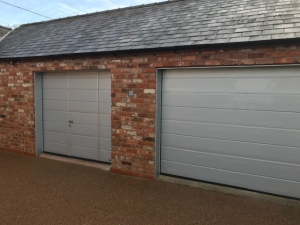 R1: Pair of Hormann LPU42 insulated sectional doors. Left one has a wicket