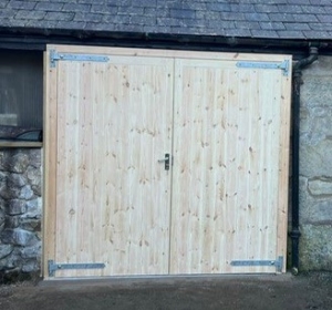 B2: Softwood, vertically planked, made to measure side hinged garage doors for store room. 